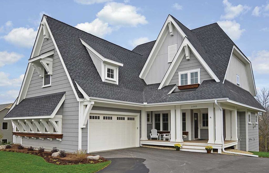 A two storey home with new lap siding, board and batten gables, and an asphalt shingle roof