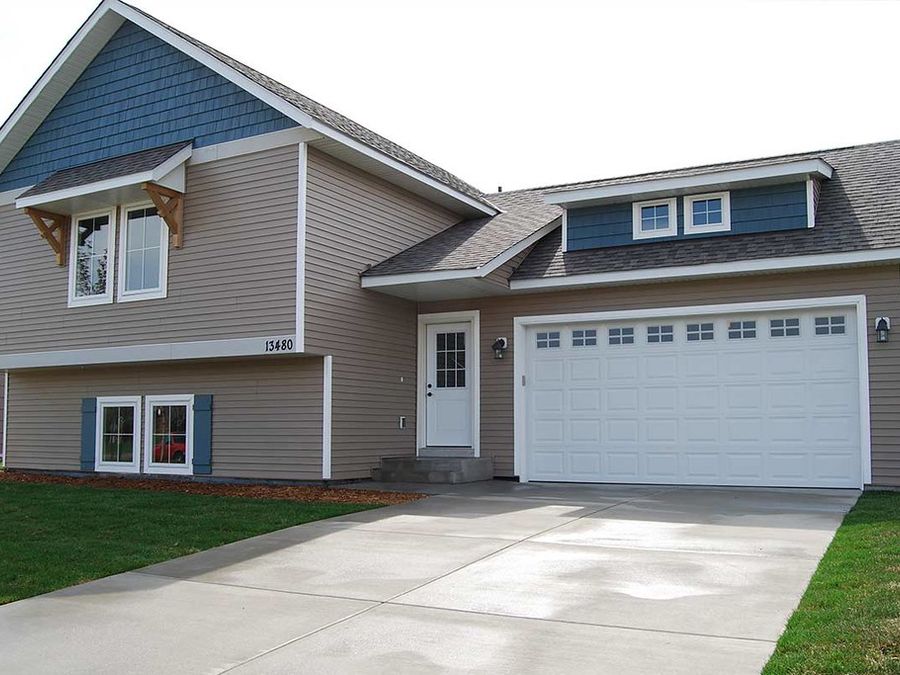 A suburban home with new siding, trim and an attached garage